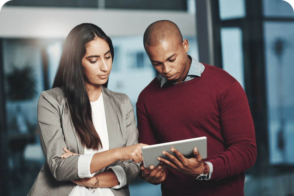 Two professionals reviewing information together on a tablet.
