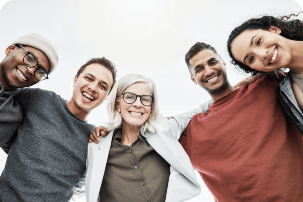 Group of diverse people smiling with their arms around each other.