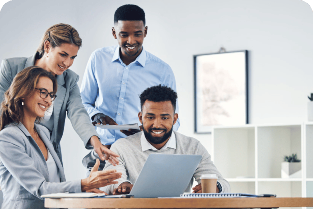 Team of professionals collaborating and reviewing work on a laptop in a modern office.