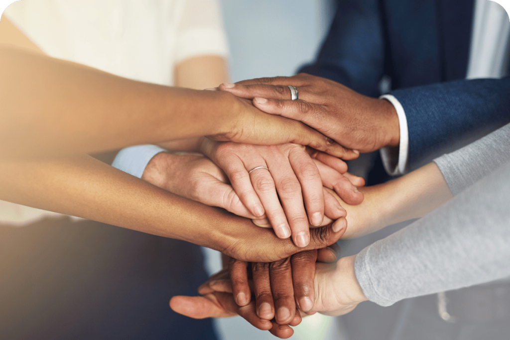 A group of diverse hands stacked together to show teamwork and unity.