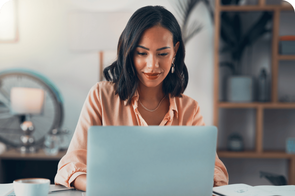 A professional woman working on a laptop in a modern office.